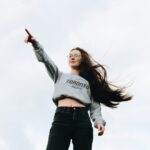 Noia segura d'ella mateixa assenyalant, transmetent confiança i determinació. Títol: "Lidera la teva vida".